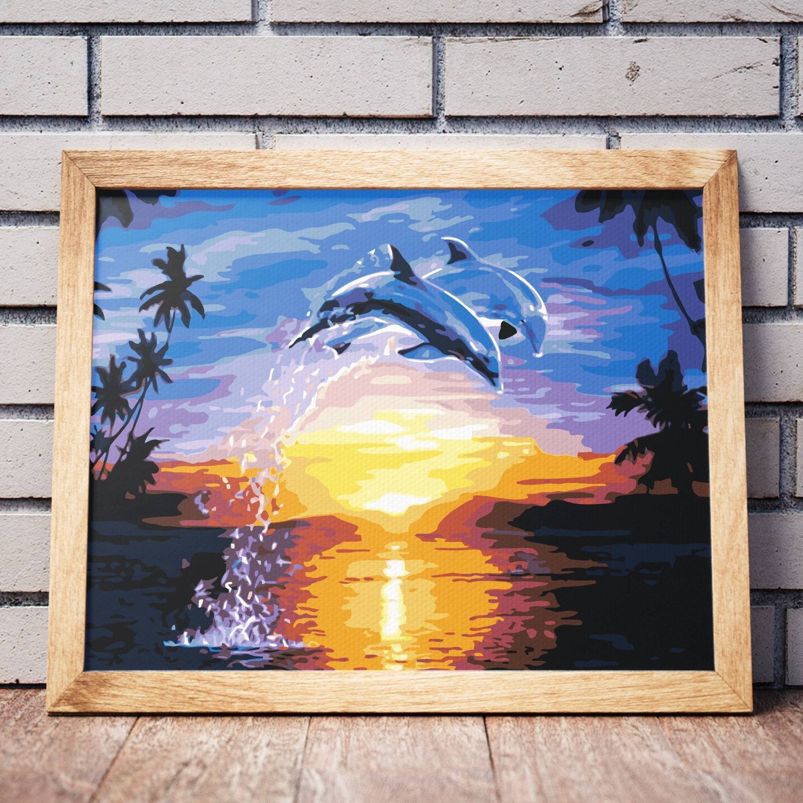 Delfiner som spelar vid solnedgången